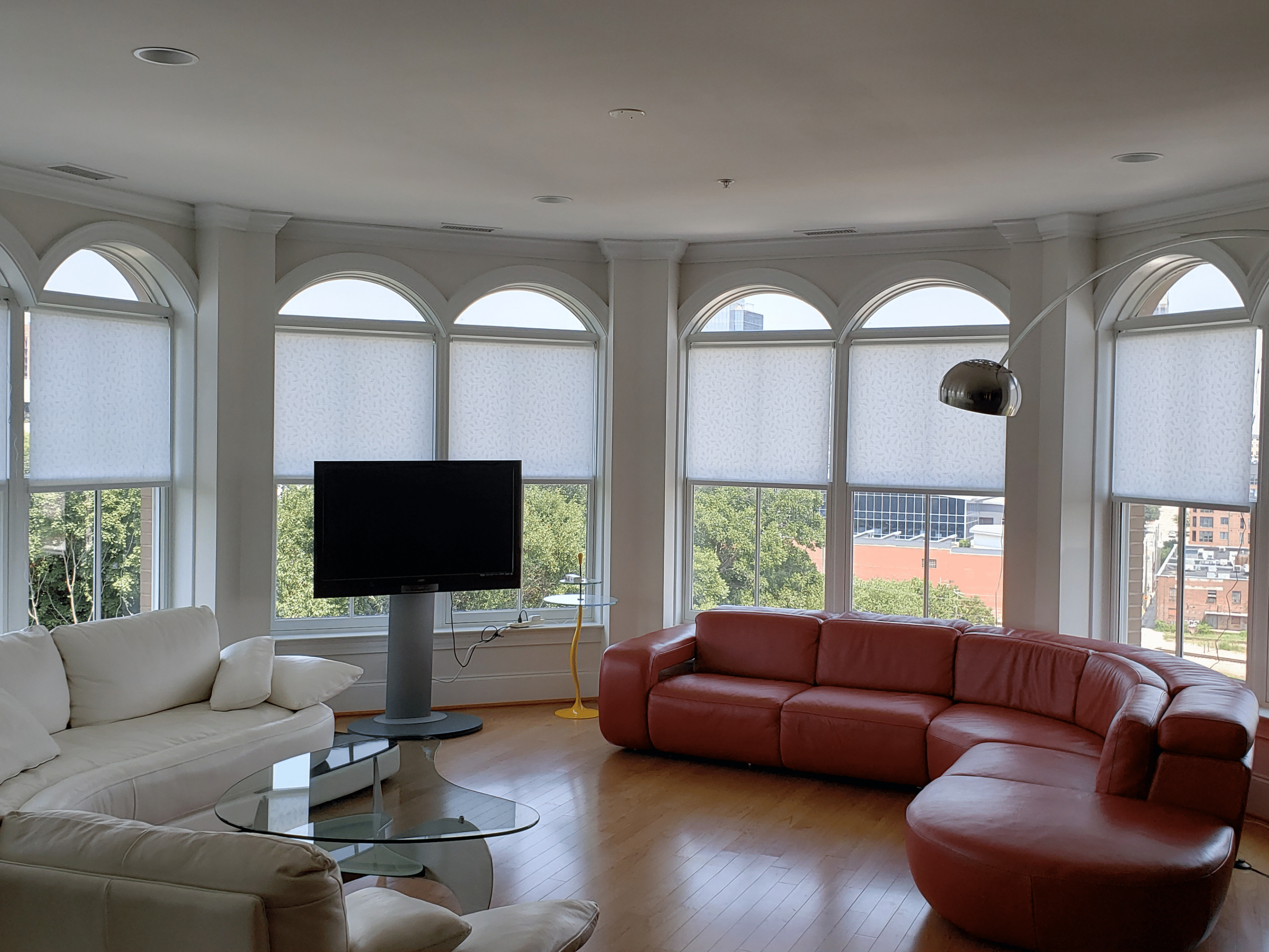 20220111_152204 Sleek roller shades filtering in natural light into a great room with a red wrap around couch,