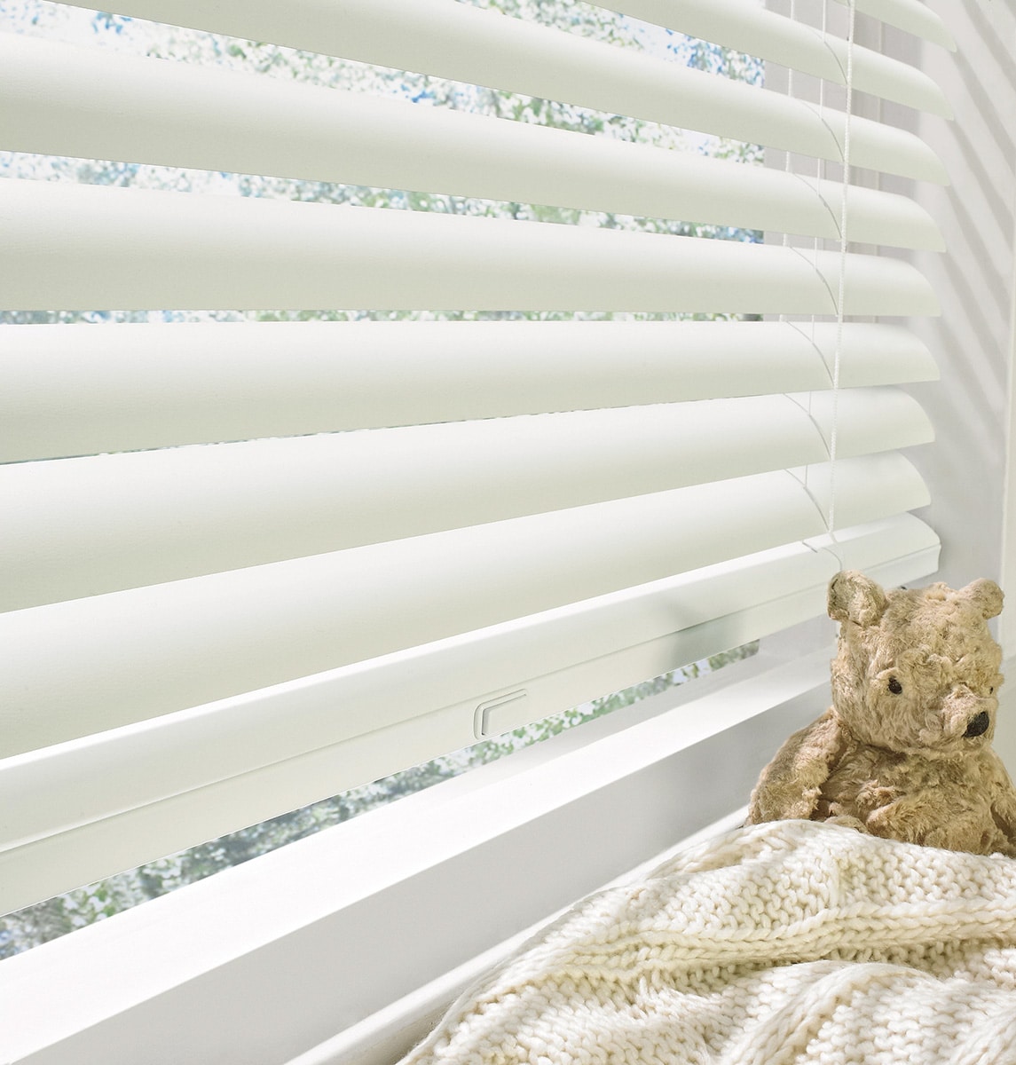 Custom Aluminum Blinds filtering in light in a children’s bedroom.