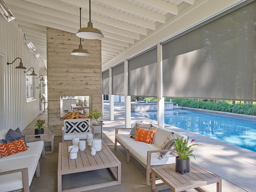 Roller shades filtering in light to a pool side patio.