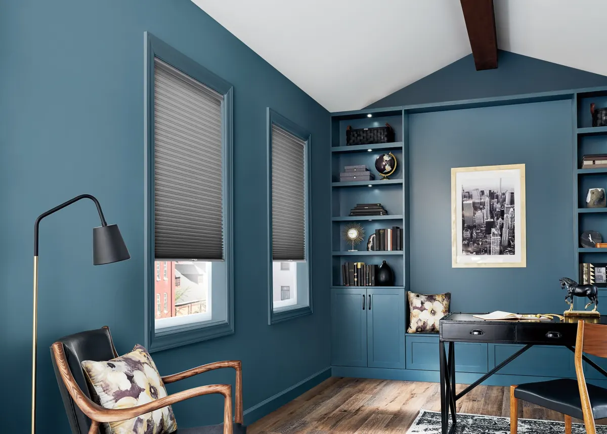 Charcoal cellular shades on two windows in a teal home office with built-in shelving in Venice, FL