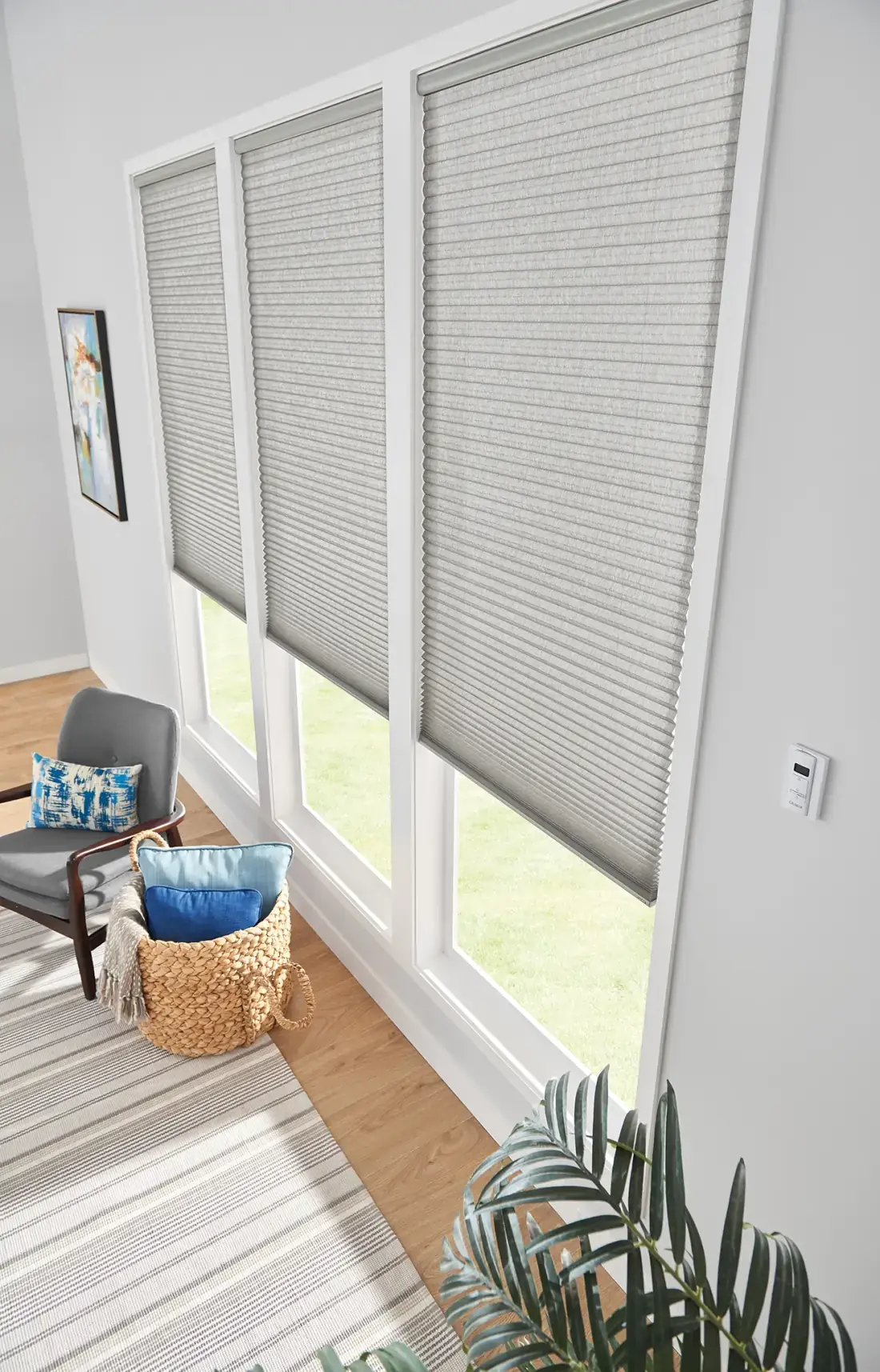 Gray cellular shades on three large patio doors in a bright sunroom with wood flooring and modern furnishings in Venice, FL