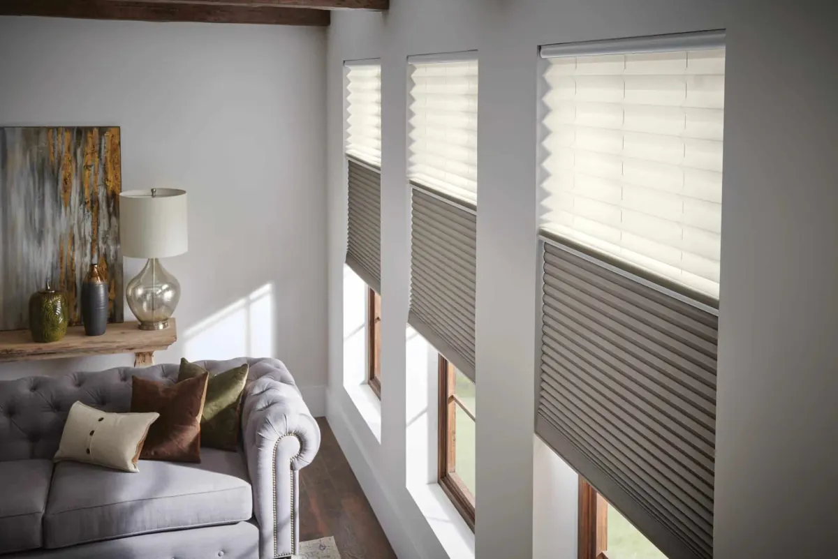 Cellular shades in white and gray filtering natural light through large living room windows beside a gray sofa in Venice, FL
