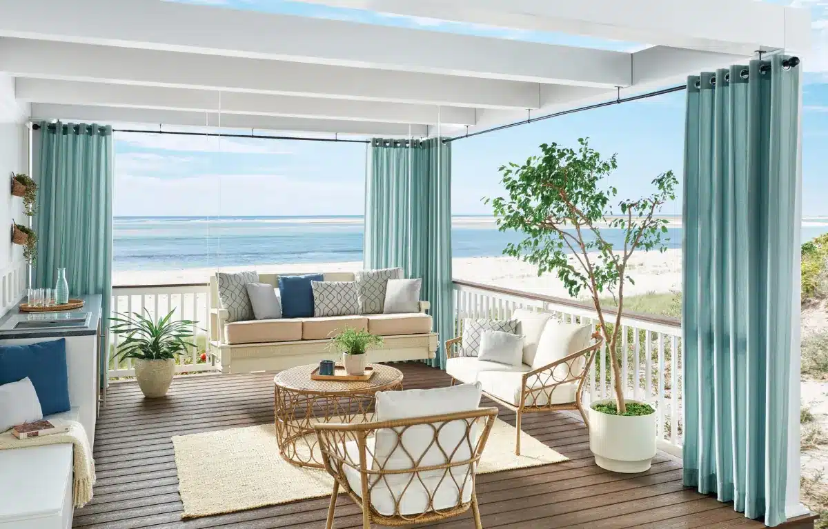 Custom floor-to-ceiling drapery panels frame an oceanfront patio with beach views in Venice, FL