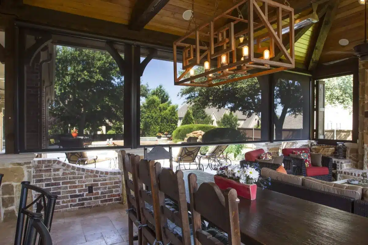 Covered patio with exterior shades framing views of landscaped yard and neighboring homes in Venice, FL