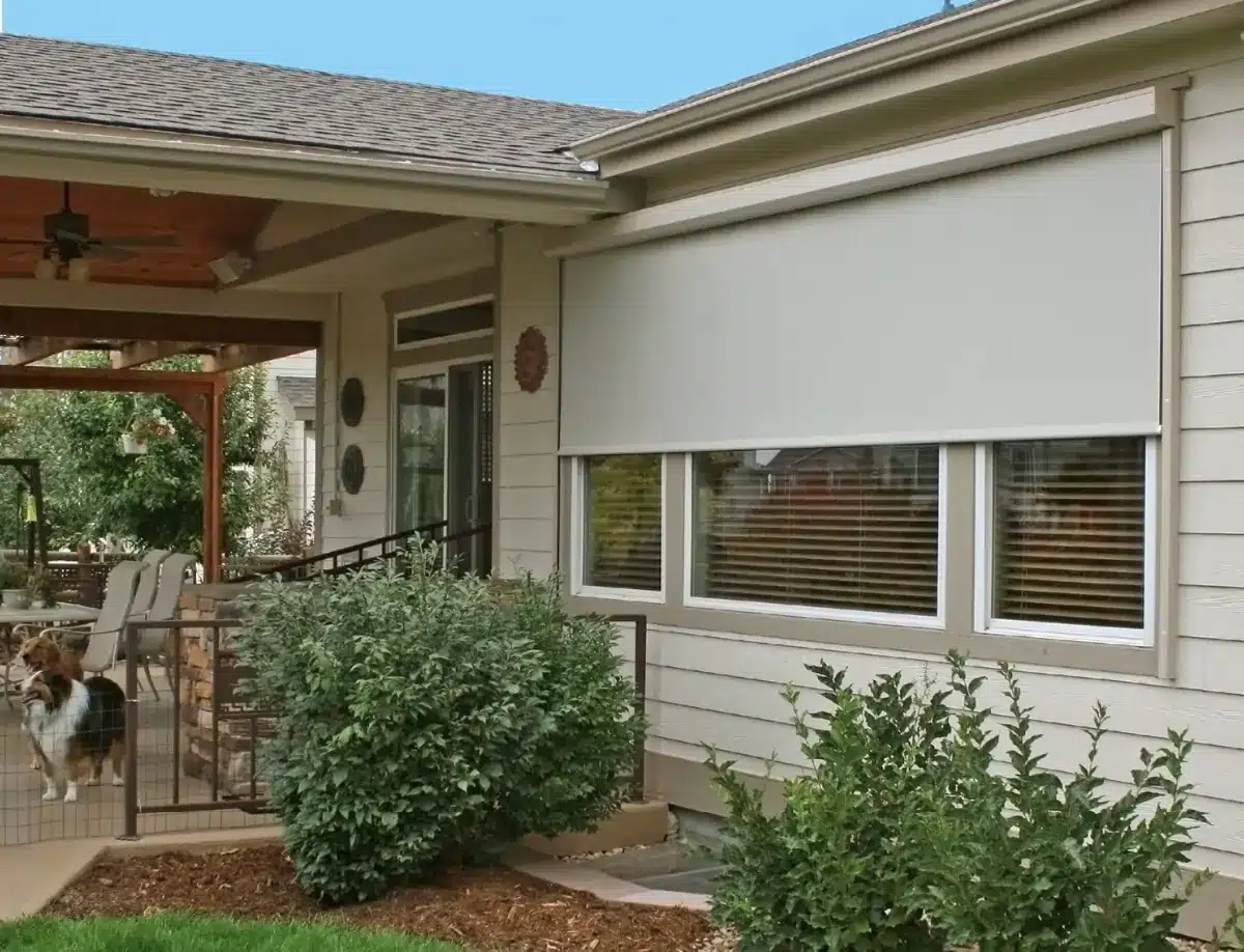 White exterior roller shades installed on patio windows with horizontal slat blinds visible behind in Venice, FL