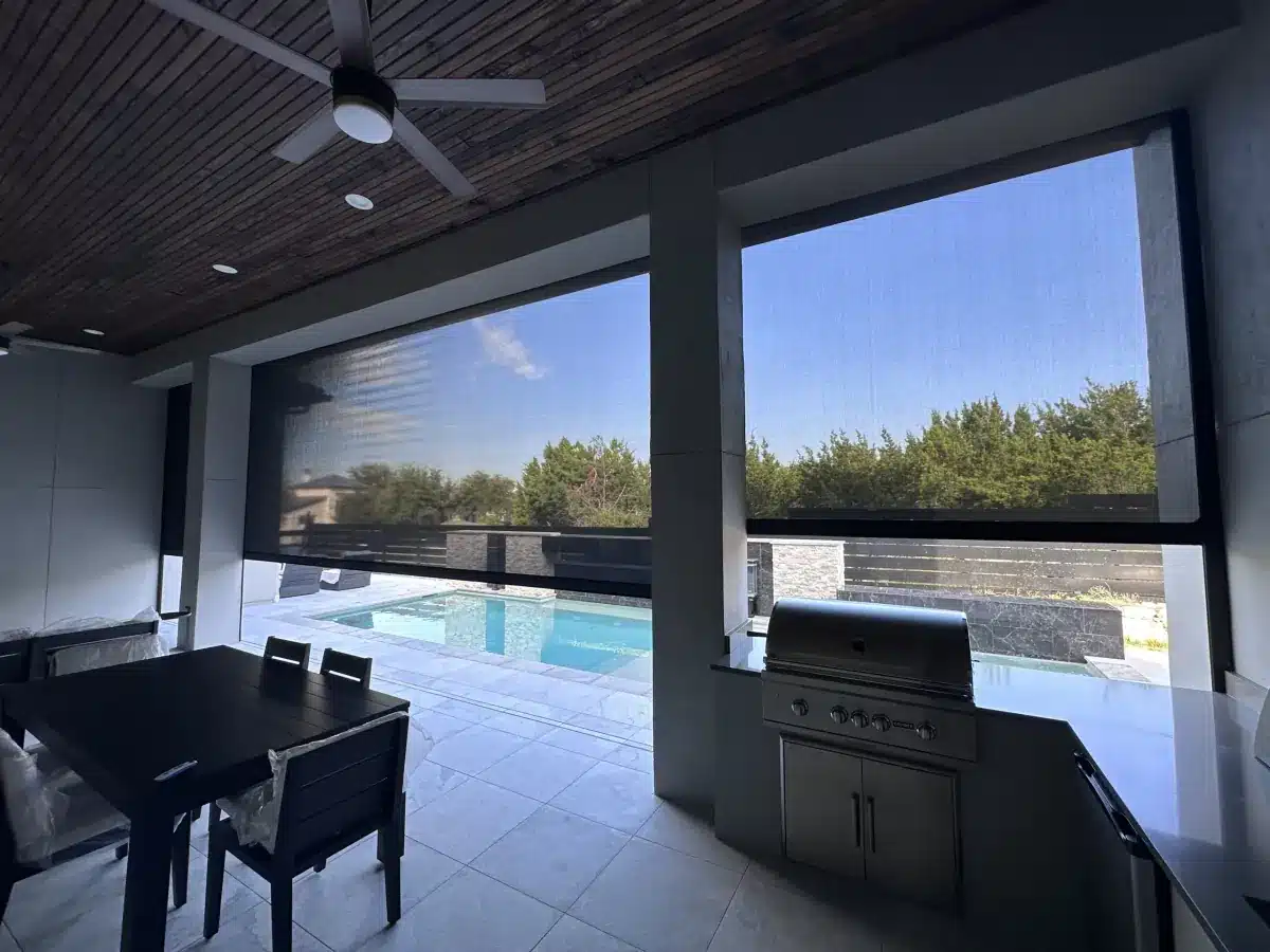 Motorized exterior solar shades on a poolside patio with dining area and outdoor kitchen in Venice, FL