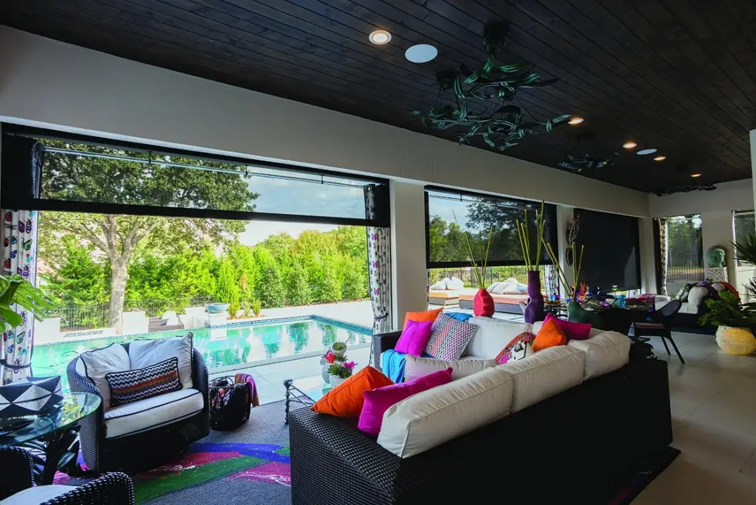 Modern patio with floor-to-ceiling exterior shades overlooking a swimming pool and landscaped grounds in Venice, FL