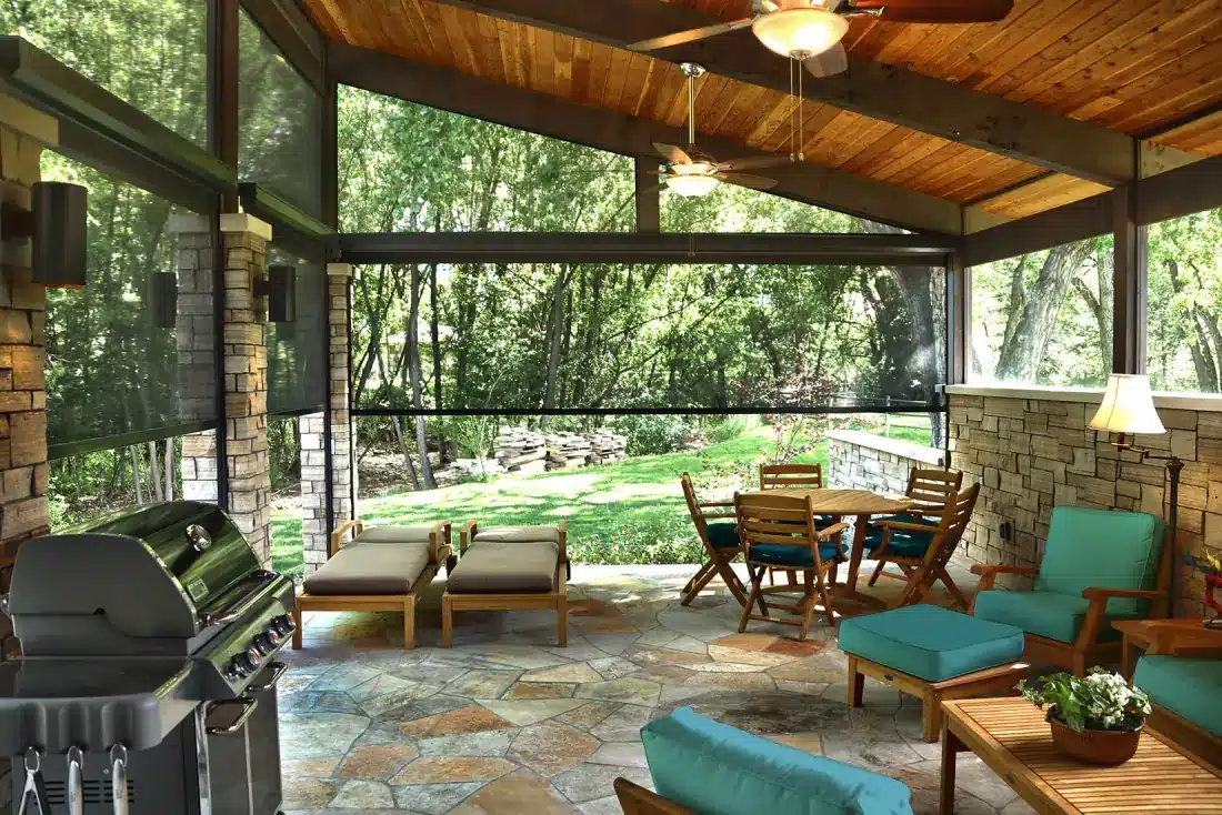 Covered patio with exterior shades, dining furniture, and lounge seating overlooking wooded landscape in Venice Covered patio with exterior shades, dining furniture, and lounge seating overlooking wooded landscape in Venice