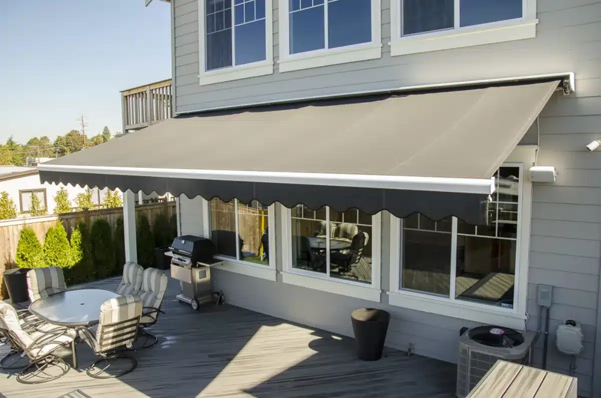 Retractable awning shading a modern deck with outdoor seating and grill in Venice, FL