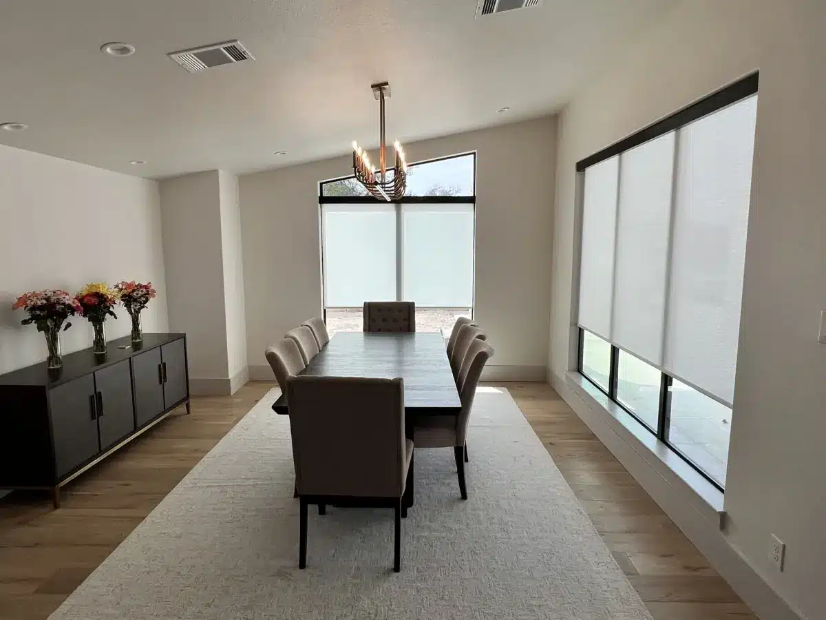 Modern dining room with white roller shades on large windows overlooking a patio in Venice, FL