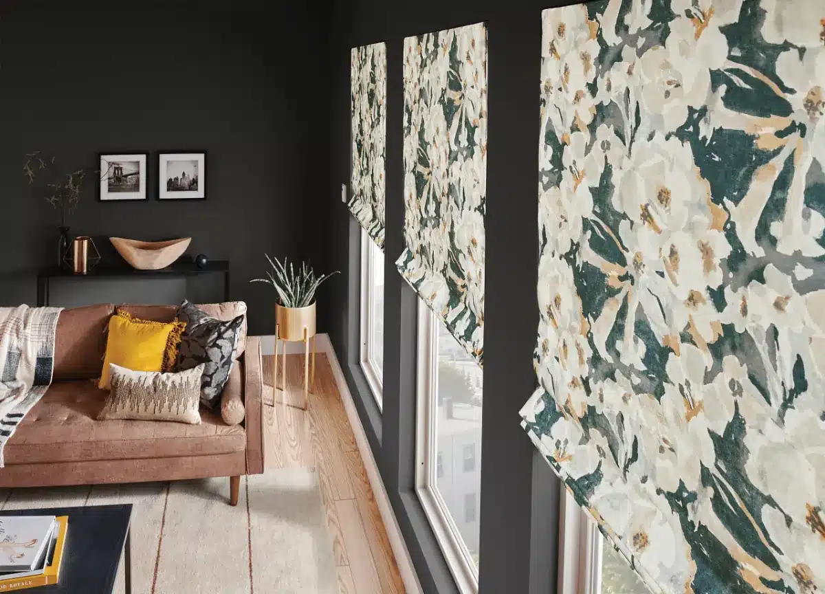 Floral roman shades with cream, green, and gold tones hang at a large window in a modern living room in Venice, FL