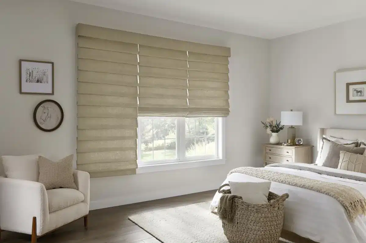 Roman shades in natural woven fabric filtering sunlight in a bright bedroom with contemporary furnishings in Venice, FL