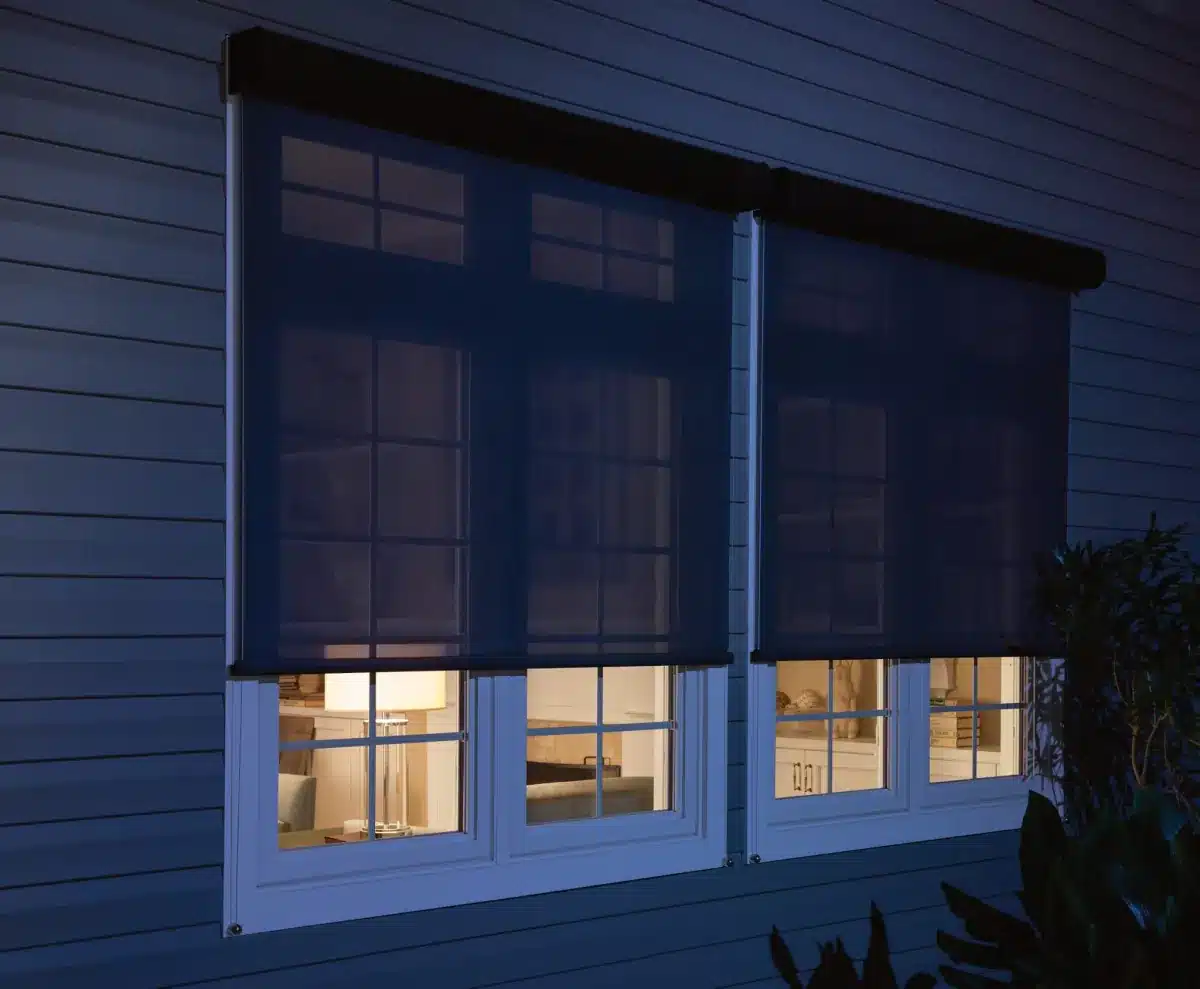 Solar shades seen through the windows of a Venice, FL home at dusk