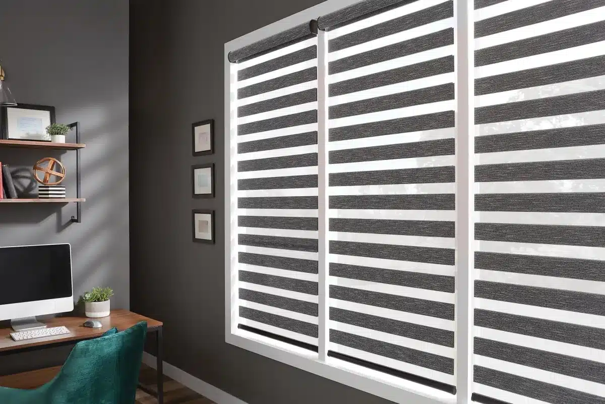 Layered gray and white solar shades on large home office window with desk setup in Venice, FL