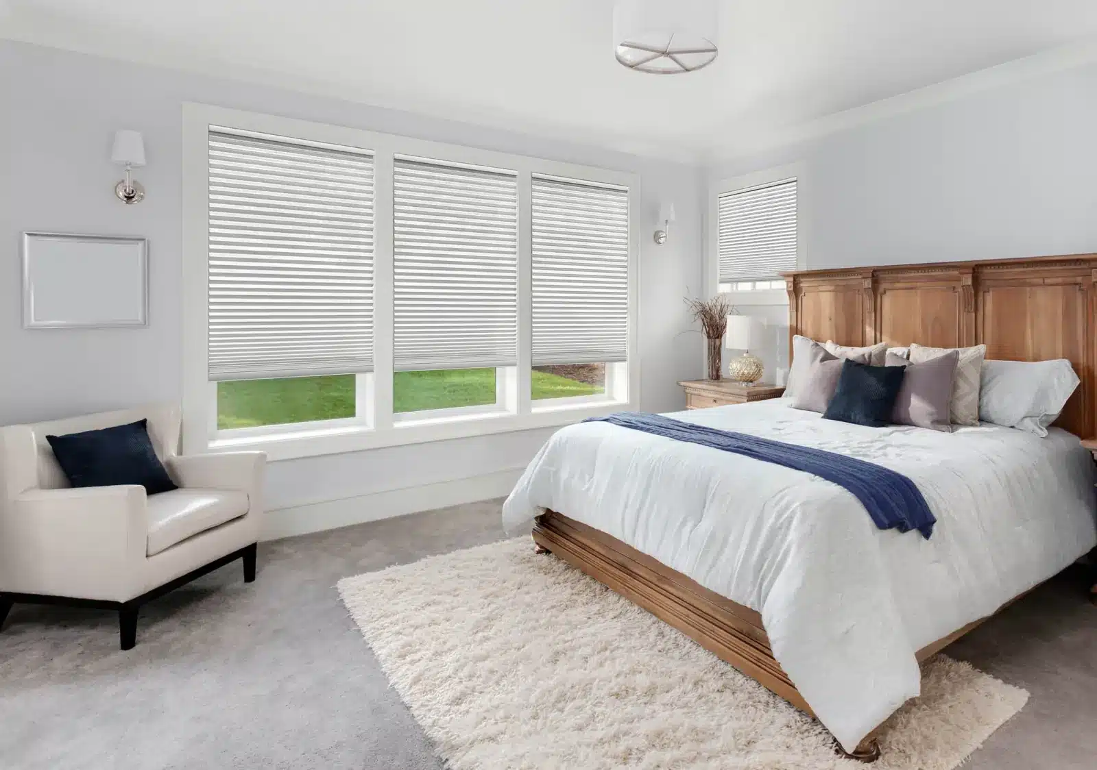 Bedroom with three large windows covered by striped solar shades filtering natural light in Venice