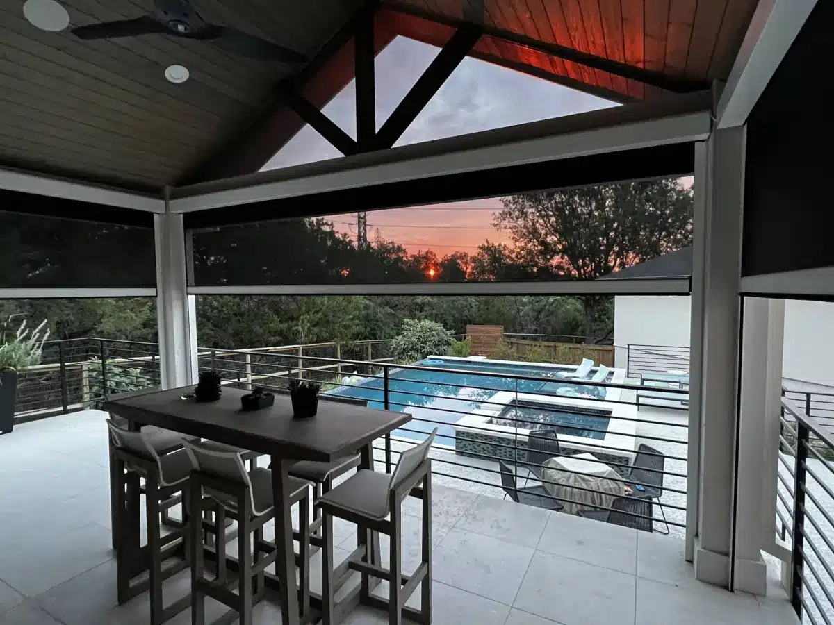 Modern patio with solar shades overlooking a pool at sunset, with dining table and ocean view in Venice, FL Modern patio with solar shades overlooking a pool at sunset, with dining table and ocean view in Venice, FL