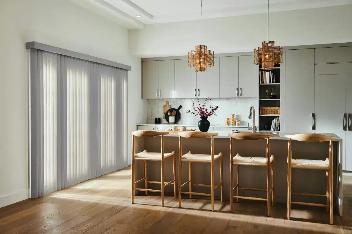 Modern kitchen with gray vertical blinds beside island seating and pendant lighting in Venice, FL
