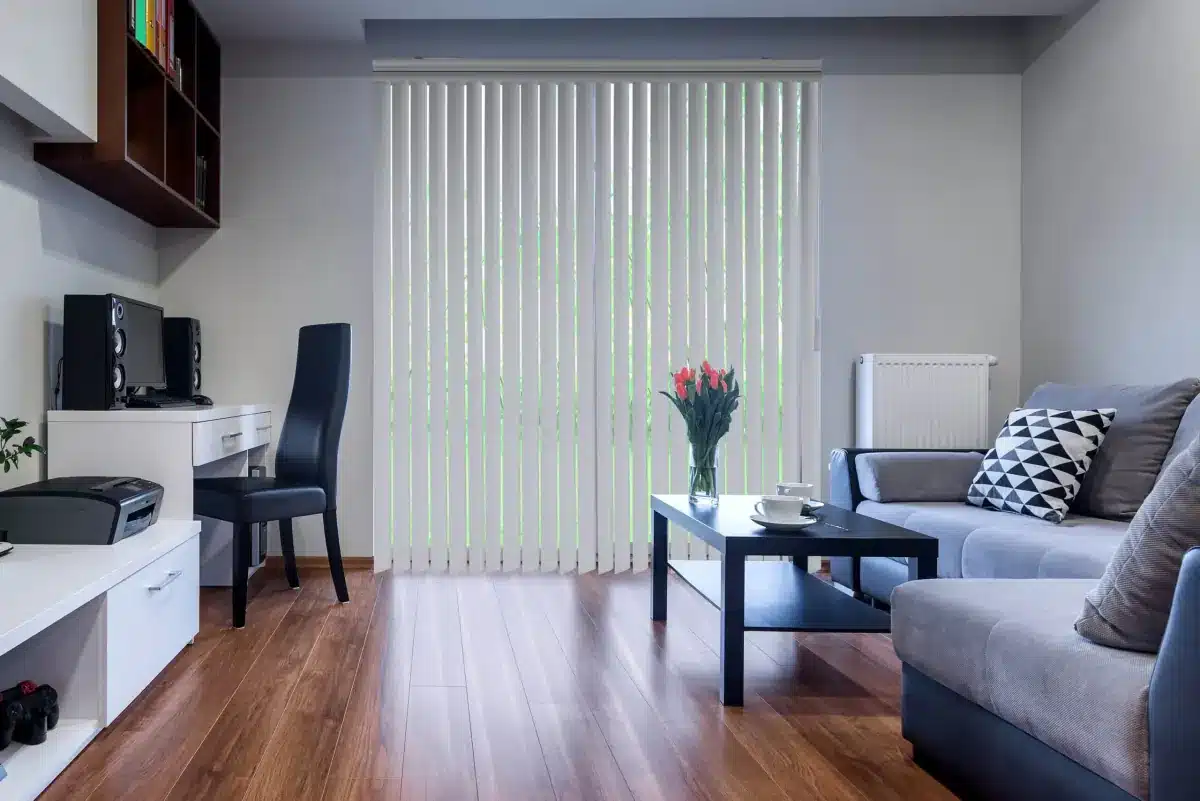 Modern living room with white vertical blinds covering large sliding glass doors in Venice, FL