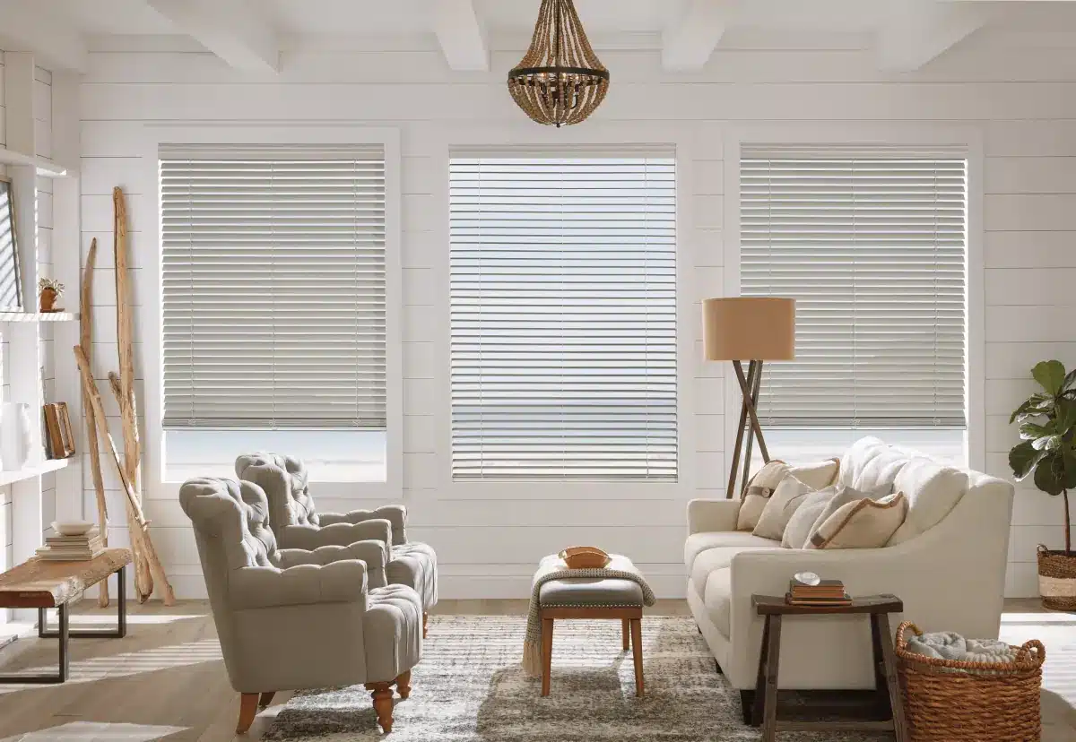 Bright living room with gray faux wood blinds on three large windows, cream furniture, and coastal decor in Venice, FL