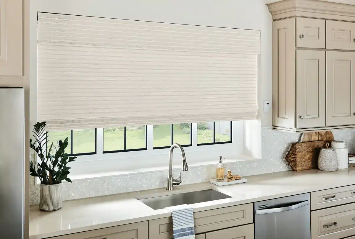 Woven wood shades in a kitchen window above the sink with a garden view in Venice, FL